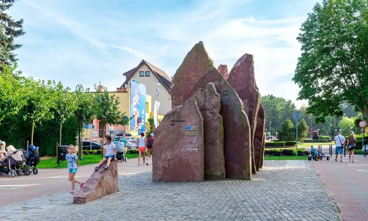 Dzieci bawią się przy kamiennym monumencie w Chłapowie. To świetne atrakcje dla dzieci, które mogą odkrywać ciekawe miejsca.