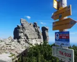 Skaliste szczyty w Karkonoszach, drogowskazy turystyczne i tablica z numerami alarmowymi. Słonecznik karkonosze.