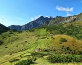 Malownicze Tatry Bielskie z krętą ścieżką wijącą się po zielonych zboczach. W oddali skaliste szczyty.