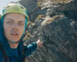 Wspinacz w kasku wskazuje drogę przez żleb Kulczyńskiego.