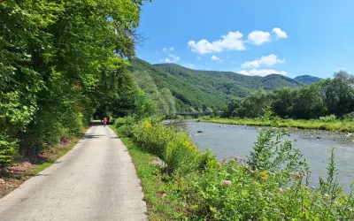 Ścieżka rowerowa wzdłuż Popradu, otoczona zielenią. Idealne miejsce na przejażdżkę velo Poprad.