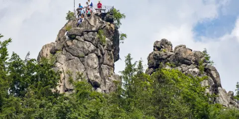 Ludzie na szczycie skalnego Sokolego Góry, podziwiający widoki.
