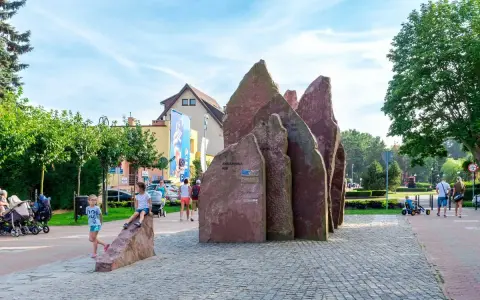 Dzieci bawią się przy kamiennym monumencie w Chłapowie. To świetne atrakcje dla dzieci, które mogą odkrywać ciekawe miejsca.