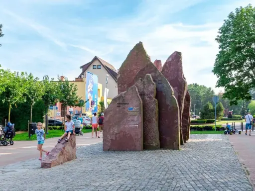 Dzieci bawią się przy kamiennym monumencie w Chłapowie. To świetne atrakcje dla dzieci, które mogą odkrywać ciekawe miejsca.