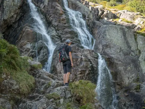 Turysta podziwia kaskady wodospadu w Tatrach Zachodnich.