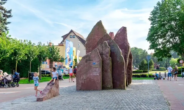 Dzieci bawią się przy kamiennym monumencie w Chłapowie. To świetne atrakcje dla dzieci, które mogą odkrywać ciekawe miejsca.
