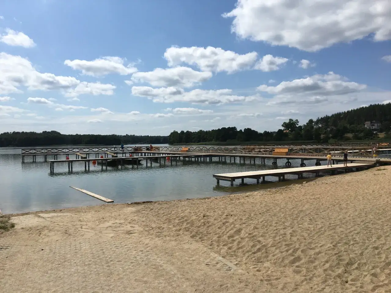 Drewniane pomosty i piaszczysta plaża nad jeziorem, idealne miejsce na wypoczynek. Gowidlino atrakcje czekają!